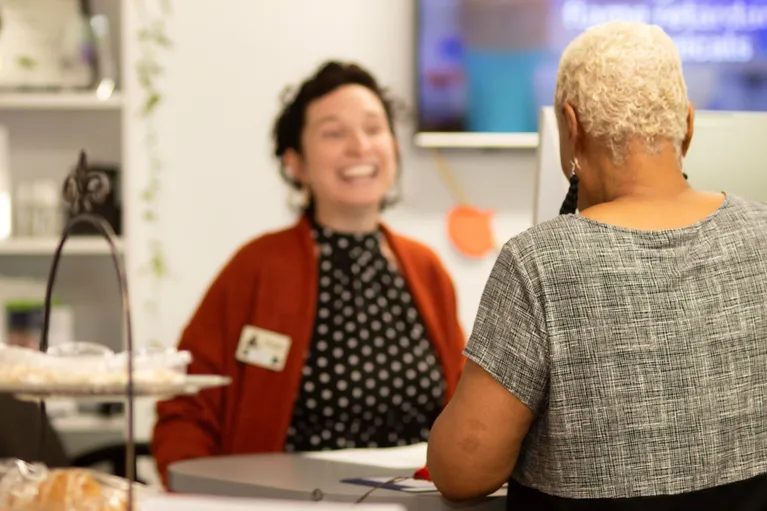 Two women talking at a desk